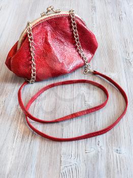 little red leather women's handbag on wooden table