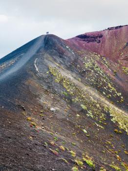 travel to Italy - people on range between craters on Mount Etna in Sicily in summer day