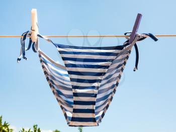 blue striped swimming panties is dried on clothesline outdoors