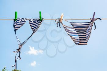 blue Striped swimsuit is dried on clothesline outdoors