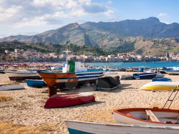 travel to Italy - urban beach with boats in Giardini Naxos town in Sicily in summer evening