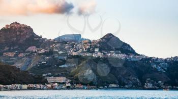 travel to Italy - Taormina city on mountain and Giardini Naxos town on waterfront of Ionian sea in Sicily in evening