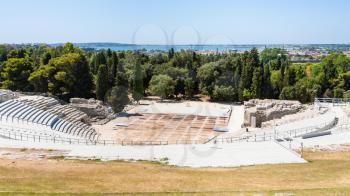 travel to Italy - above view of Greek theater in Archaeological Park (Parco Archeologico della Neapolis) of Syracuse city and sea coastline in Sicily