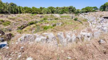 travel to Italy - view of ancient roman Amphitheatre (Anfiteatro romano di Siracusa) in Archaeological Park (Parco Archeologico della Neapolis) of Syracuse city in Sicily