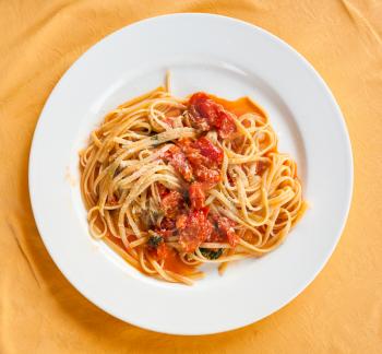 travel to Italy, italian cuisine - top view spaghetti with spicy tomato sauce on white plate in Sicily
