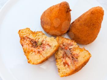 travel to Italy, italian cuisine - local meal arancini ( fried rice filled balls with filling coated with breadcrumbs) on white plate in Sicily