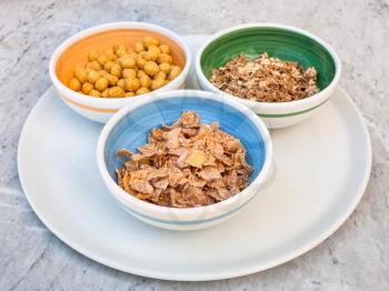 various cold breakfast cereals in bowls on white plate