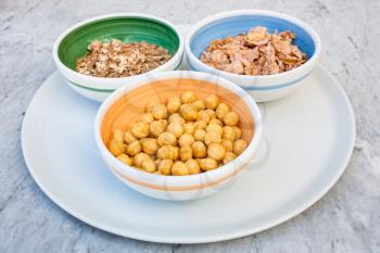 three kind of cold breakfast cereals in bowls on white plate
