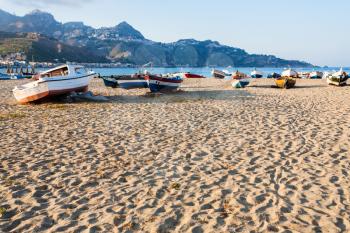 travel to Italy - sand beach with boats in Giardini Naxos town in Sicily in summer evening