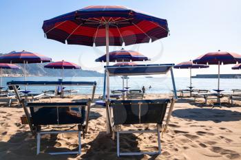 travel to Italy - chairs on urban beach in giardini naxos town in Sicily in morning
