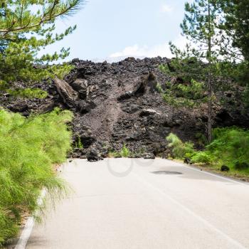 travel to Italy - hardened lava flow on road on slope of Etna volcano in Sicily