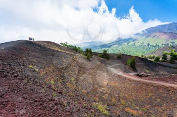 travel to Italy - tourists walk on ridge between old crater of Etna volcano in Sicily