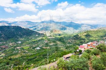 travel to Italy - above view of green gardens and Francavilla di Sicilia town in mountain valley from Castiglione di Sicilia town in Sicily