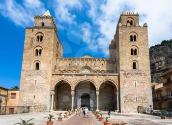 CEFALU, ITALY - JUNE 25, 2011: visitors near entrance in Duomo di Cefalu in Sicily. Cathedral - Basilica of Cefalu was erected in 1131 in the Norman architectural style