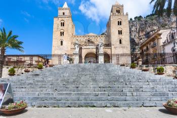 CEFALU, ITALY - JUNE 25, 2011: tourists near gate in Duomo di Cefalu in Sicily. Cathedral - Basilica of Cefalu was erected in 1131 in the Norman architectural style