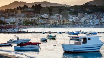 GIARDINI NAXOS, ITALY - JULY 6, 2011: boats in marina of Giardini Naxos town in evening. Naxos was founded by Thucles the Chalcidian in 734 BC, and since 1970s it has become a seaside-resort