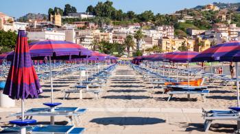 GIARDINI NAXOS, ITALY - JULY 8, 2011: people on urban beach of Giardini Naxos town in morning. Naxos was founded by Thucles the Chalcidian in 734 BC, and since 1970s it has become a seaside-resort