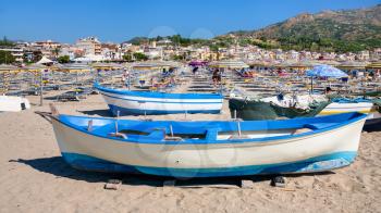 GIARDINI NAXOS, ITALY - JUNE 30, 2011: people and boats on urban beach in Giardini Naxos town. Naxos was founded by Thucles the Chalcidian in 734 BC, and since 1970s it has become a seaside-resort