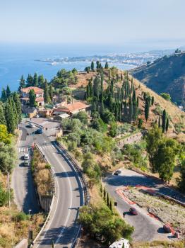 TAORMINA, ITALY - JULY 2, 2011: above view of road to Tairmina town and Ionian sea coastline with Giardini Naxos village in Sicily. Taormina is a small resort city on the east coast of Sicily