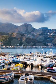 GIARDINI NAXOS, ITALY - JULY 6, 2011: yacht mooring in Giardini Naxos town in evening. Naxos was founded by Thucles the Chalcidian in 734 BC, and since 1970s it has become a seaside-resort