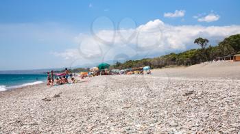 CALATABIANO, ITALY - JULY 6, 2011: tourists on pebble beach San Marco on Ionian Sea coast in Sicily. This is clean, long, calm, small pebbled beach, it is free for most of the extension.