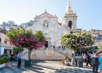 TAORMINA, ITALY - JULY 2, 2011: people near Church of San Giuseppe in Piazza IX Aprile in Taormina city in Sicily. The church was built between late 1600 and early 1700