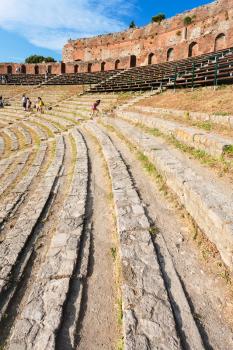 TAORMINA, ITALY - JULY 2, 2011: stone seats in ancient Teatro Greco (Greek Theatre) in Taormina city in Sicily. Arena was built in the third century BC.