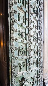 MONREALE, ITALY - JUNE 25, 2011: bronze doors of Duomo di Monreale in Sicily. The cathedral of Monreale is one of the greatest examples of Norman architecture, it was begun in 1174