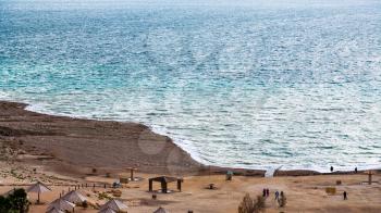 Travel to Middle East country Kingdom of Jordan - view of beach of Dead Sea from Jordan shore in winter evening