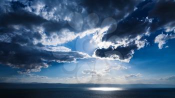 Travel to Middle East country Kingdom of Jordan - sunbeams passes through dark blue clouds over Dead Sea in winter evening