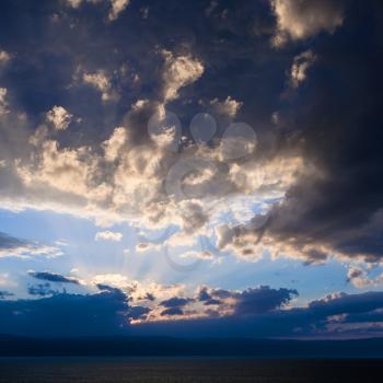 Travel to Middle East country Kingdom of Jordan - dark blue sunset clouds over Dead Sea in winter evening