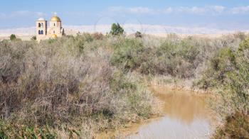 Travel to Middle East country Kingdom of Jordan - Jordan River and Greek Orthodox Church of John the Baptist in Holy Land near Baptism Site Bethany Beyond the Jordan (Al-Maghtas) in sunny winter day