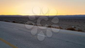 Travel to Middle East country Kingdom of Jordan - yellow sunset and Desert Highway (Road 15) in Jordan in winter