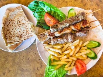 Travel to Middle East country Kingdom of Jordan - top view of portion of various arabian kebabs in restaurant in Petra town