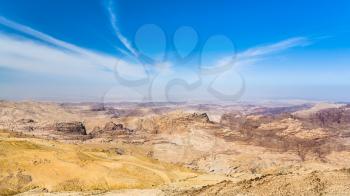 Travel to Middle East country Kingdom of Jordan - blue sky over sedimentary rocks around Wadi Araba (Arabah, Arava, Aravah) area near Petra town in sunny winter day