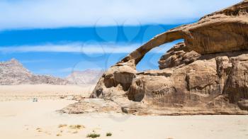Travel to Middle East country Kingdom of Jordan - car near sandstone rock in Wadi Rum desert in sunny winter day