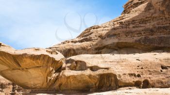 Travel to Middle East country Kingdom of Jordan - old sandstone rocks in Wadi Rum desert in sunny winter day