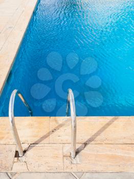 empty outdoor swimming pool with blue water