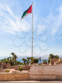 Travel to Middle East country Kingdom of Jordan - Flag of the Arab Revolt over Aqaba Fort in Aqaba city