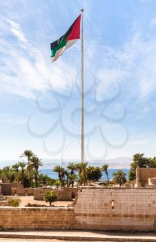 Travel to Middle East country Kingdom of Jordan - Flag of the Arab Revolt over Aqaba Castle in Aqaba city