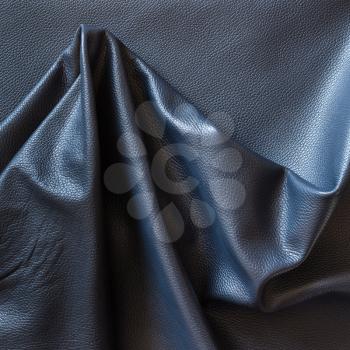 background from crumpled piece of black cattle genuine leather