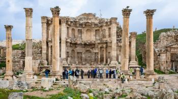 JERASH, JORDAN - FEBRUARY 18, 2012: tourists near Nymphaeum in Geraca town in winter. Greco-Roman town Gerasa (Antioch on the Golden River) was founded by Alexander the Great or his general Perdiccas