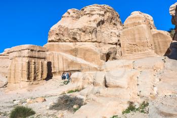 PETRA, JORDAN - FEBRUARY 21, 2012: tourists near Djinn Blocks at Bab as-Siq road to Petra town in winter. Rock-cut town Petra was established about 312 BC as the capital city of the Arab Nabataean