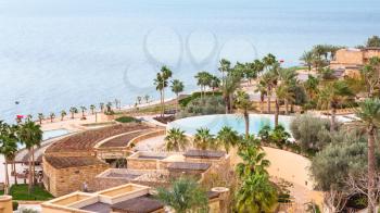 DEAD SEA, JORDAN - FEBRUARY 19, 2012: Kempinski spa resort hotel Ishtar and Dead Sea in winter season. The Dead Sea is is deepest hypersaline lake in the world bordered by Jordan, Israel and Palestine
