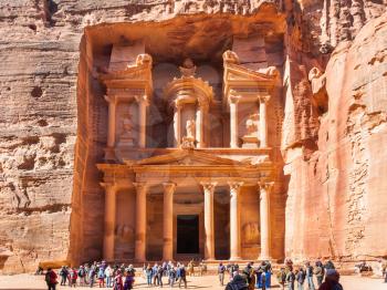 PETRA, JORDAN - FEBRUARY 21, 2012: people near al-Khazneh temple (The Treasury) in ancient Petra. Rock-cut town Petra was established about 312 BC as the capital city of the Arab Nabataean