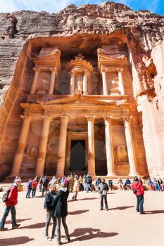 PETRA, JORDAN - FEBRUARY 21, 2012: tourists on plaza near al-Khazneh temple (The Treasury) in ancient Petra. Rock-cut town Petra was established about 312 BC as the capital city of the Arab Nabataean