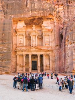 PETRA, JORDAN - FEBRUARY 21, 2012: people in front of al-Khazneh temple (The Treasury) in Petra town. Rock-cut town Petra was established about 312 BC as the capital city of the Arab Nabataean