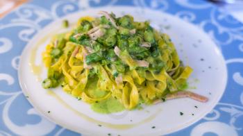 travel to Italy - plate with tagliatelle, asparagus and ham in restaurant in Verona city in spring
