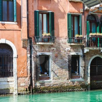 travel to Italy - facade of old urban house on waterfront of canal in Venice city in spring