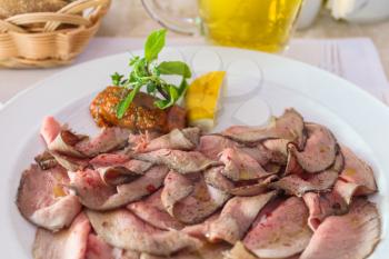 sliced roast beef close up on plate in italian restaurant